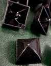 Boutons en métal, de forme pyramidale, 18 mm de côté, laqués noir. Nombre très limité.