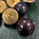 Boutons métalliques bombés à bourrelets périphériques, diam 22 mm, laqués noir. Nombre très limité.