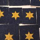 Un petit bout d'histoire (belge) pas cher. Croix à 6 branches jaunes sur fond gris de fer bleuté. Prix à l'unité