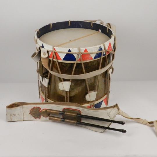 Tambour peint aux couleurs nationales, avec baudrier surpiqué à la grenade, garni de ses baguettes.