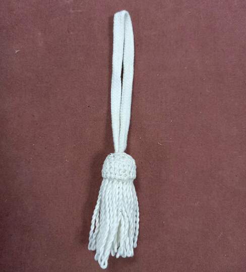Pompon blanc avec attache par lacet plat