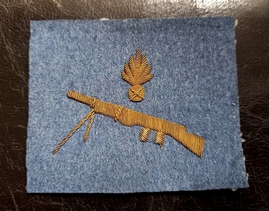 Insigne de servant de fusil Mitrailleur Chauchat. Broderie de fusil mitrailleur or/bleu horizon. Grande Guerre